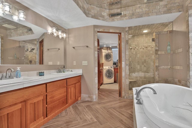 bathroom with stacked washer and dryer, shower with separate bathtub, parquet floors, and vanity