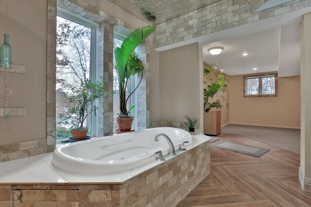 bathroom with parquet floors and tiled bath