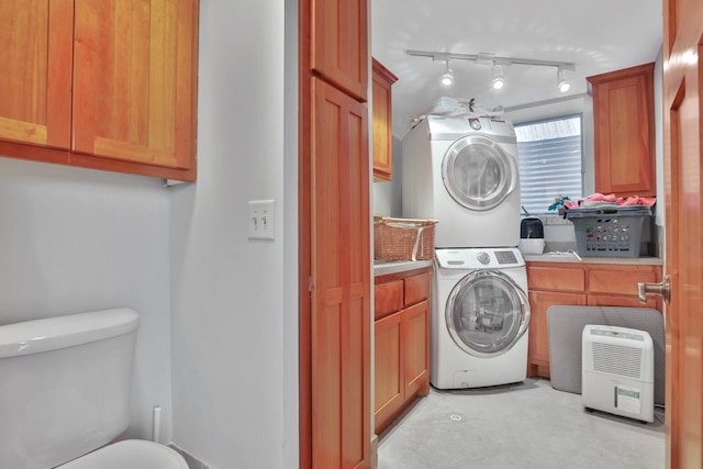 washroom with stacked washing maching and dryer and track lighting