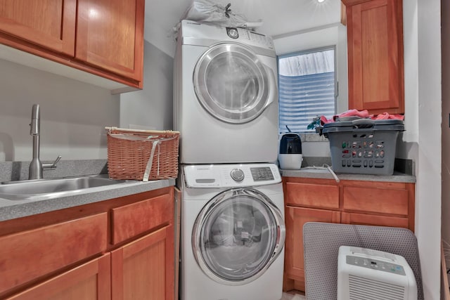 laundry room with cabinets, stacked washing maching and dryer, and sink