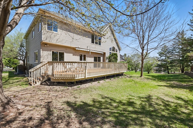 rear view of house featuring a yard and a wooden deck