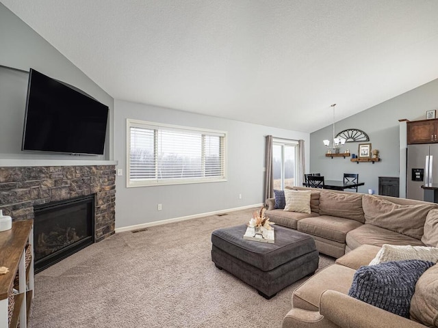 carpeted living room with a fireplace, a chandelier, and vaulted ceiling