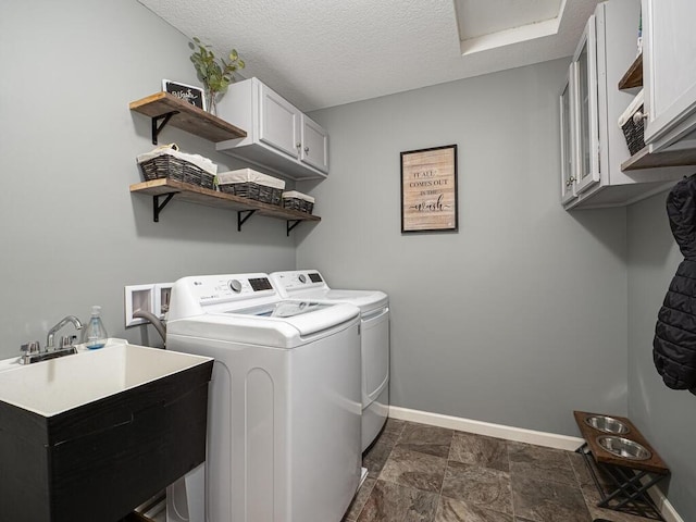 washroom with washer and clothes dryer, cabinets, a textured ceiling, and sink