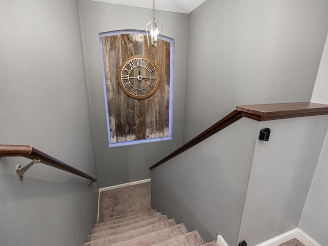 stairway featuring carpet floors and a notable chandelier