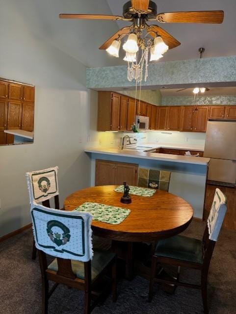 dining room with ceiling fan, dark carpet, and sink