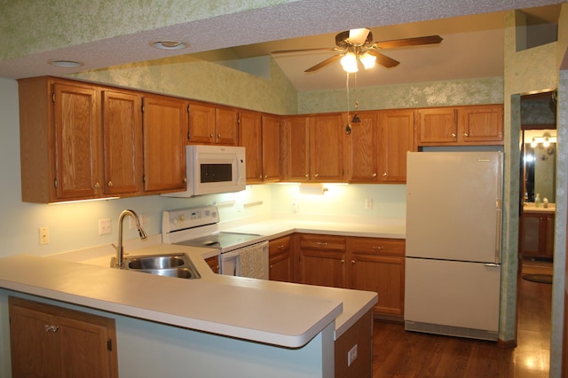 kitchen featuring lofted ceiling, white appliances, dark wood-type flooring, sink, and kitchen peninsula