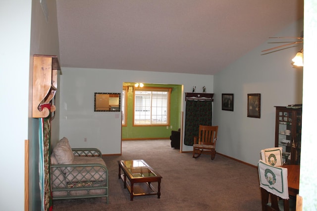 carpeted living room with ceiling fan and vaulted ceiling