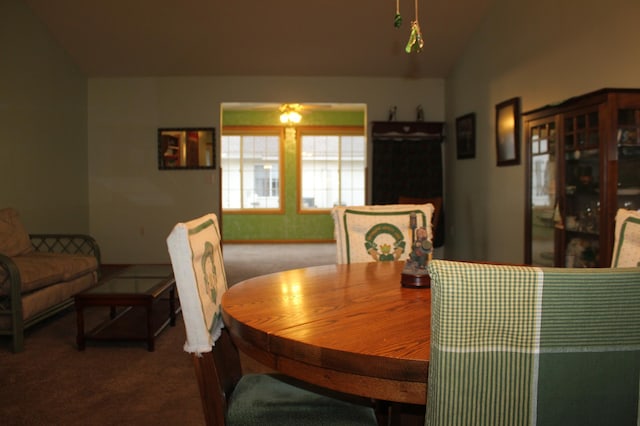 carpeted dining space featuring lofted ceiling