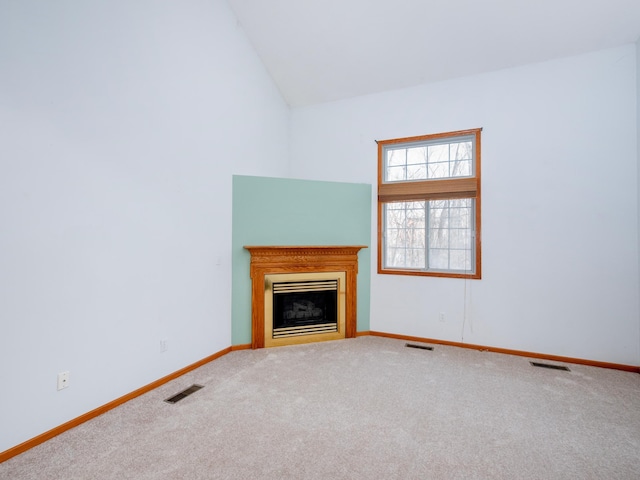 unfurnished living room with vaulted ceiling and carpet