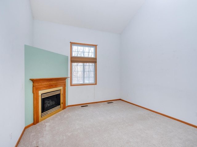 unfurnished living room with vaulted ceiling and carpet