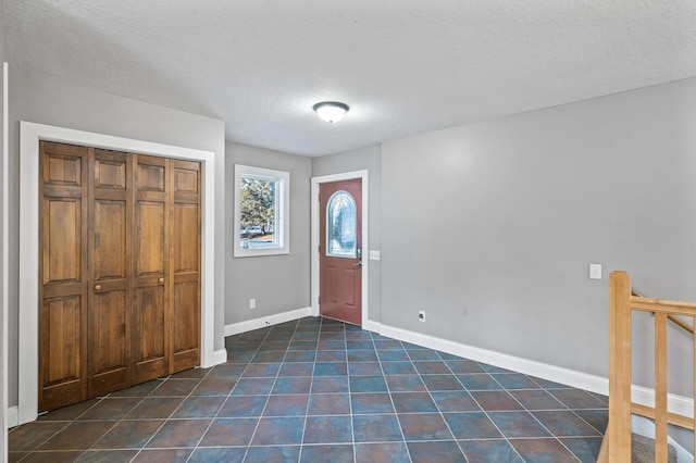 foyer entrance with a textured ceiling