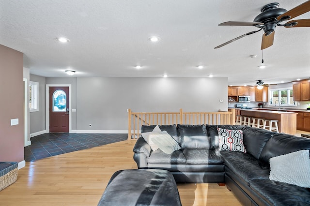 living room featuring tile patterned flooring, a textured ceiling, and sink