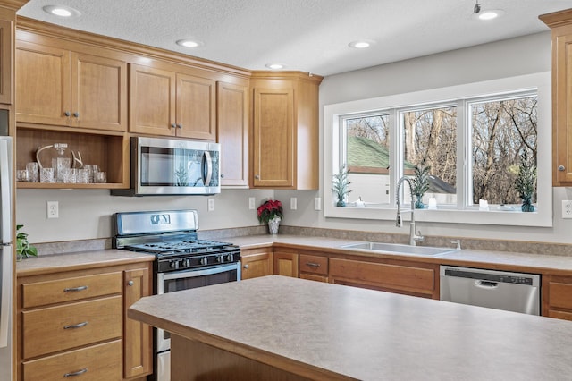 kitchen featuring a textured ceiling, sink, and stainless steel appliances