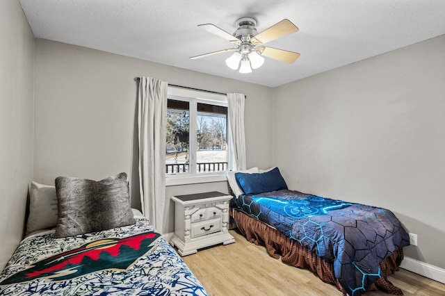 bedroom with hardwood / wood-style floors, ceiling fan, and a textured ceiling