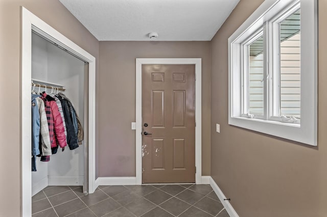 doorway with dark tile patterned flooring