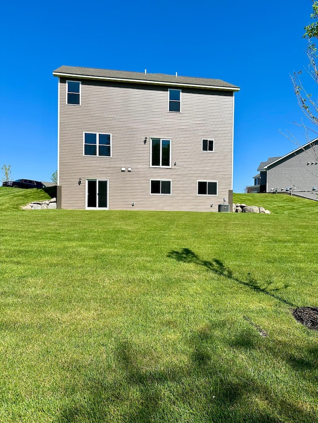 rear view of property featuring a lawn