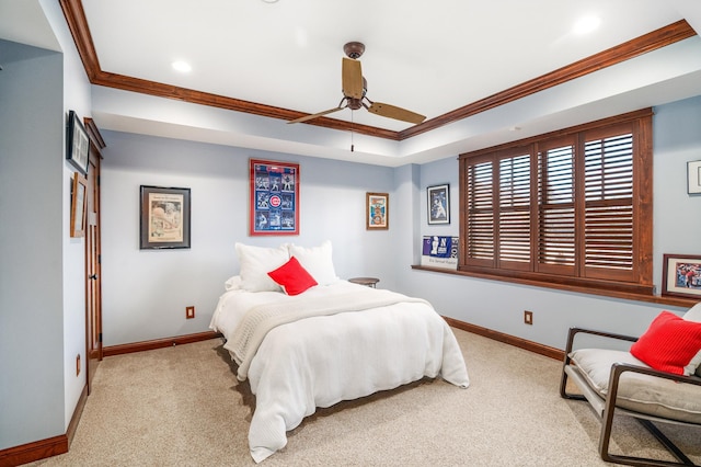 carpeted bedroom featuring a tray ceiling, ceiling fan, and ornamental molding