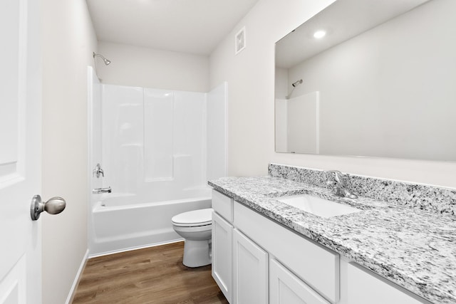 full bathroom with shower / bathing tub combination, hardwood / wood-style floors, vanity, and toilet