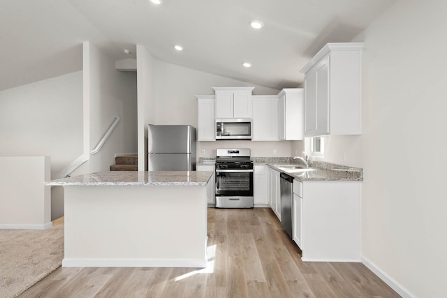 kitchen featuring white cabinetry, a kitchen island, lofted ceiling, and appliances with stainless steel finishes