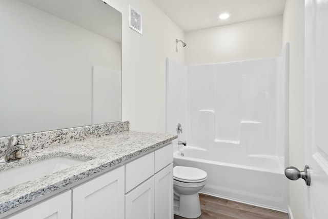 full bathroom featuring hardwood / wood-style floors, vanity, bathing tub / shower combination, and toilet