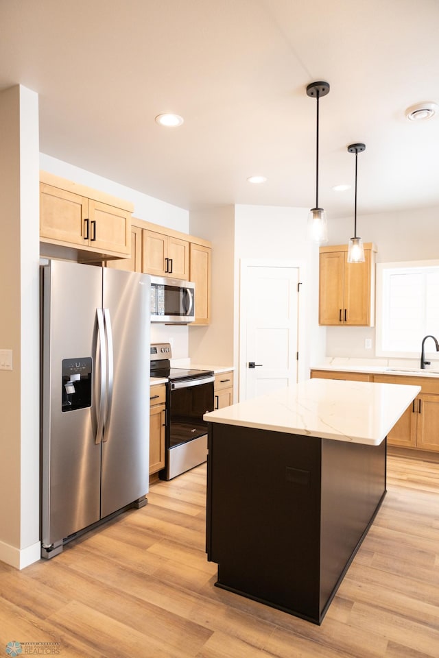 kitchen featuring stainless steel appliances, light hardwood / wood-style flooring, decorative light fixtures, light brown cabinetry, and a kitchen island