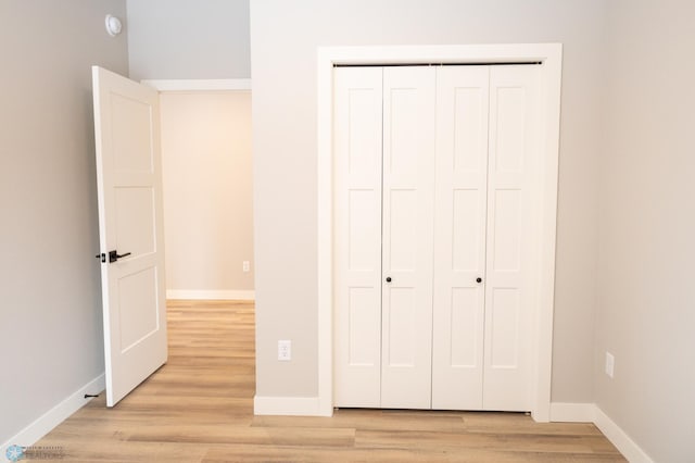 unfurnished bedroom featuring light wood-type flooring and a closet