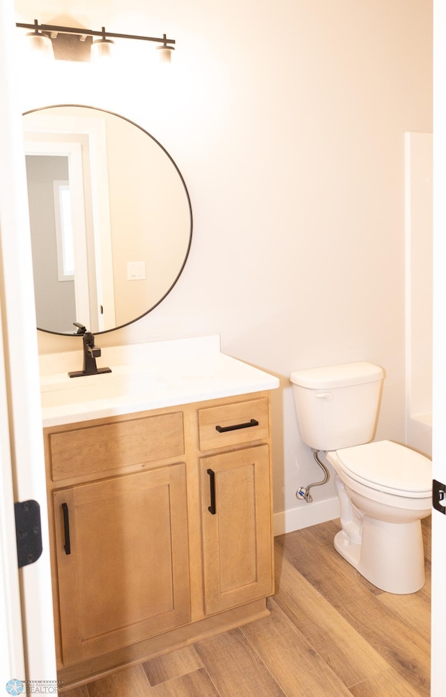 bathroom featuring vanity, wood-type flooring, and toilet