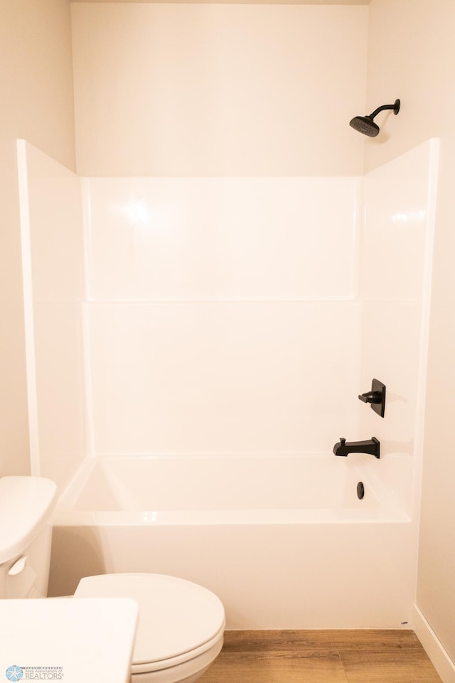 bathroom with bathing tub / shower combination, hardwood / wood-style flooring, and toilet