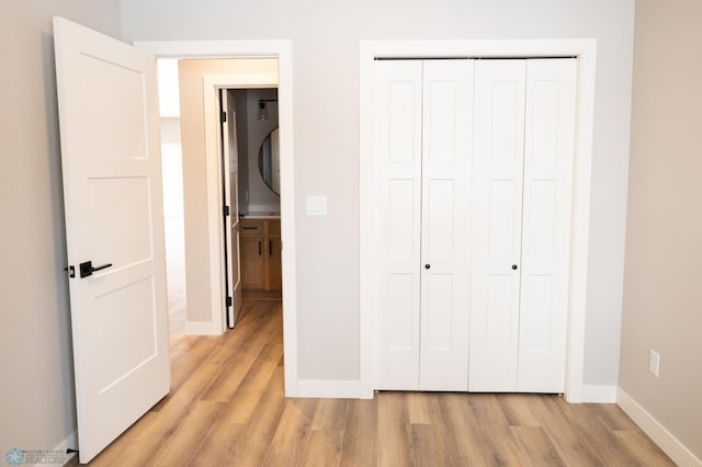 unfurnished bedroom with a closet and light hardwood / wood-style floors