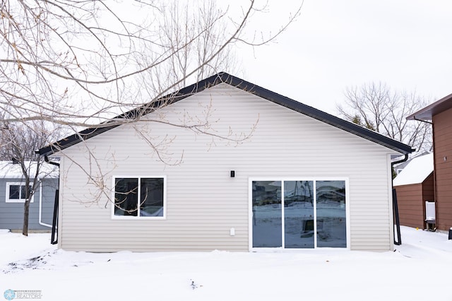 view of snow covered back of property