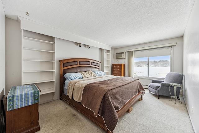 bedroom with a wall unit AC, a textured ceiling, baseboard heating, and carpet