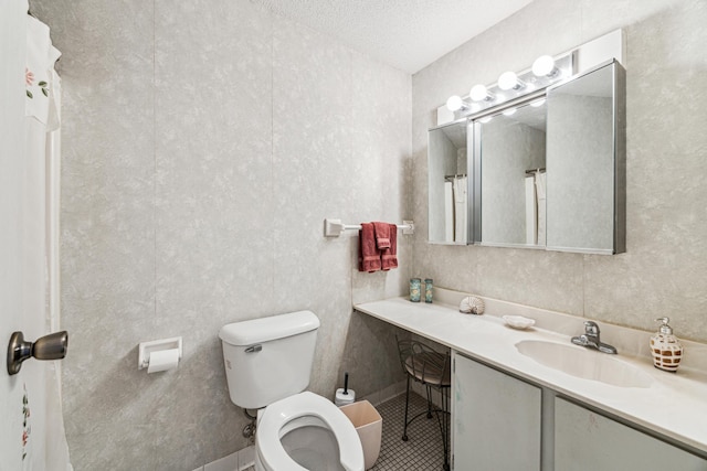 bathroom featuring toilet, vanity, and a textured ceiling