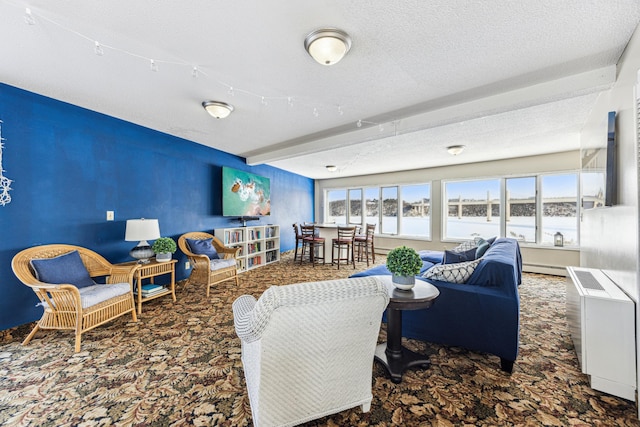 carpeted living room featuring a textured ceiling, a baseboard radiator, and beamed ceiling