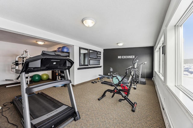 workout area with a healthy amount of sunlight, baseboard heating, and a textured ceiling