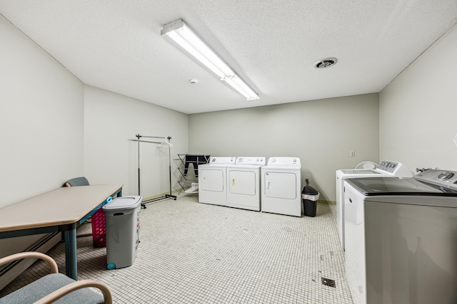 laundry room with a textured ceiling and independent washer and dryer