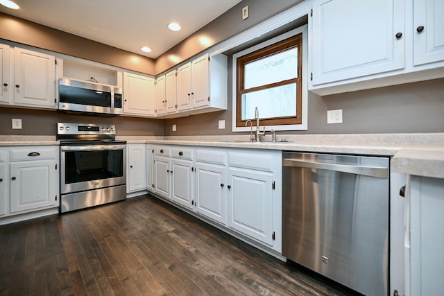 kitchen with stainless steel appliances, white cabinetry, dark hardwood / wood-style floors, and sink