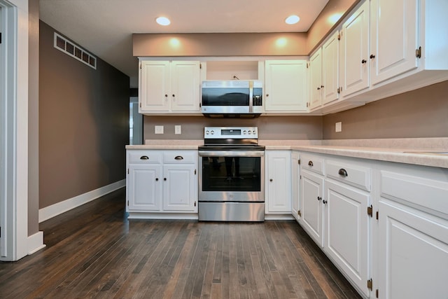 kitchen with white cabinets, dark hardwood / wood-style flooring, and appliances with stainless steel finishes