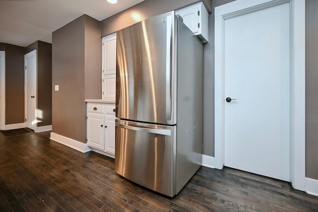 kitchen with white cabinets, dark hardwood / wood-style floors, and stainless steel fridge