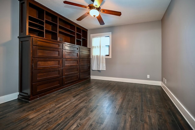 unfurnished bedroom with ceiling fan and dark wood-type flooring