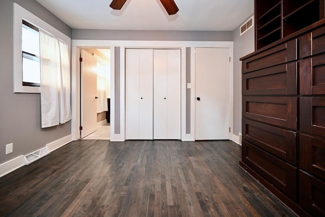 unfurnished bedroom with ceiling fan and dark hardwood / wood-style floors