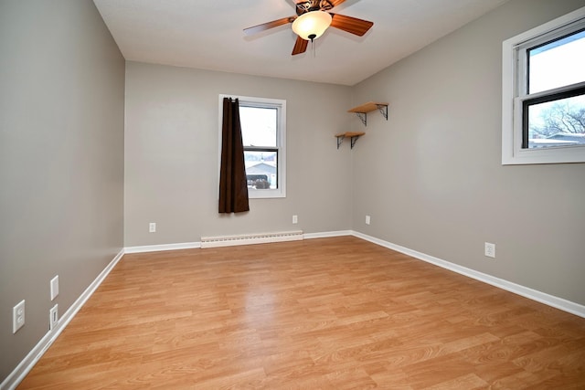 unfurnished room featuring a healthy amount of sunlight, light hardwood / wood-style floors, and a baseboard heating unit