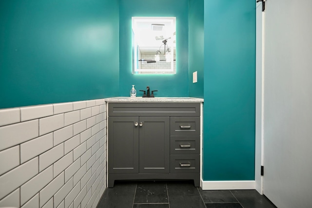 bathroom featuring tile patterned floors, vanity, and tile walls