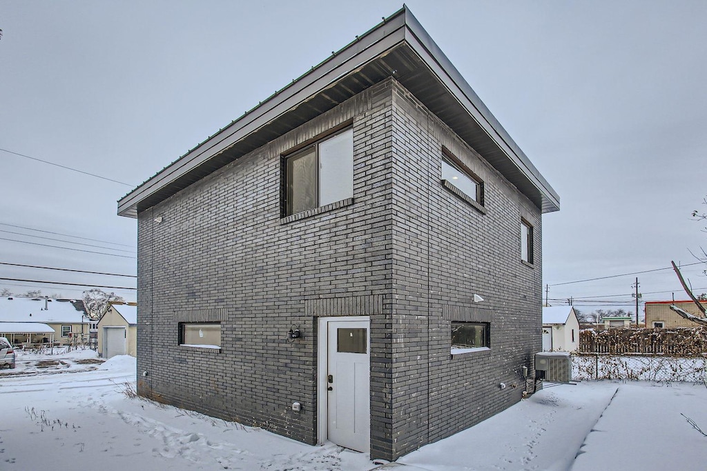 view of snowy exterior with cooling unit