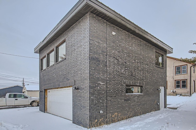 snow covered property with a garage