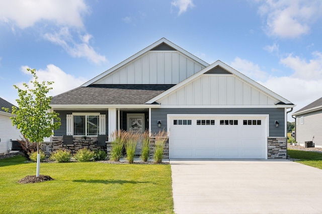 craftsman-style home featuring cooling unit, a front yard, and a garage