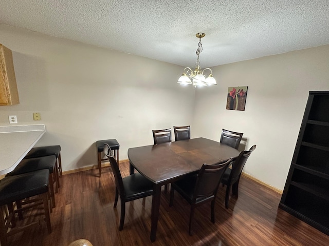 dining space featuring a textured ceiling, a notable chandelier, and dark wood-type flooring