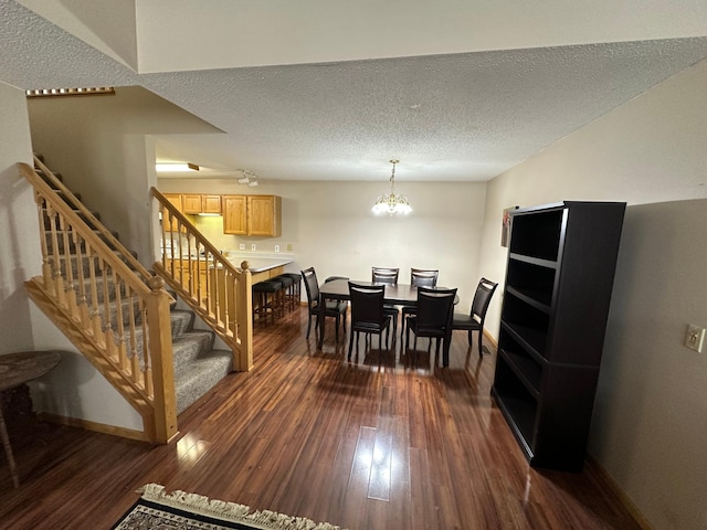 dining space with a notable chandelier, dark hardwood / wood-style floors, and a textured ceiling