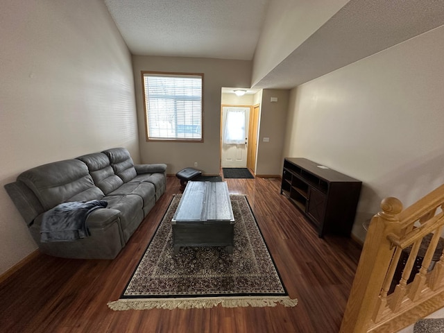 living room featuring a textured ceiling, vaulted ceiling, and dark wood-type flooring