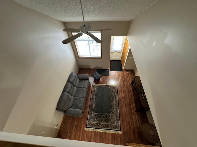 unfurnished living room featuring ceiling fan and a textured ceiling