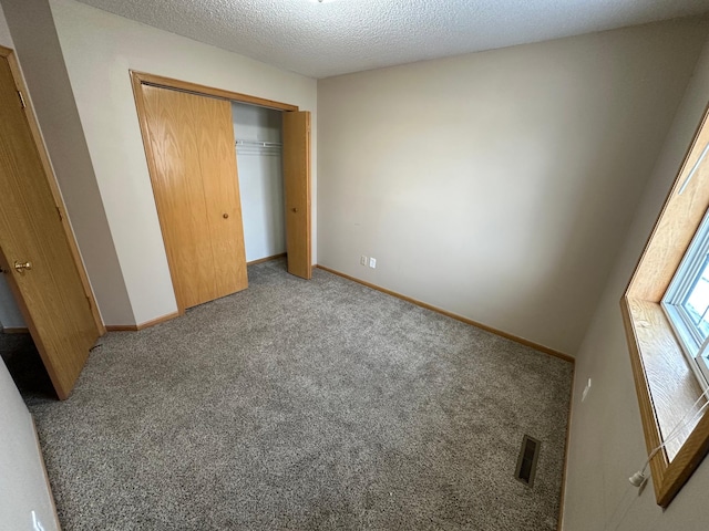 unfurnished bedroom with a closet, carpet, and a textured ceiling